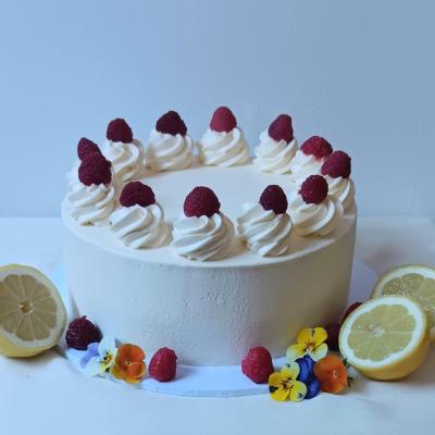 Sandwiched and coated in lemon flavoured buttercream, decorated with buttercream piping and fresh raspberries.